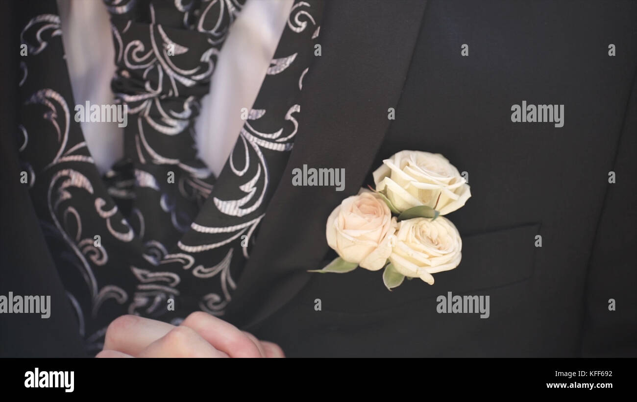 Fleur d'oeillet dans une poche. la fleur dans la poche de la veste. épingle avec des fleurs blanches décoratives épinglées sur la veste du marié. fleur boutonnière dans la poche du marié lors de la cérémonie de mariage Banque D'Images