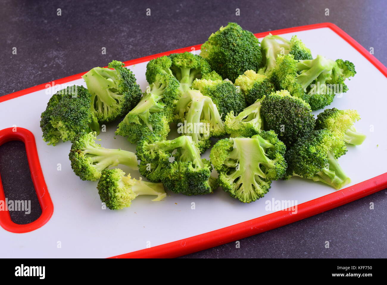 Le brocoli sur une planche à découper blanc sur un fond gris. étape par étape la cuisson Banque D'Images