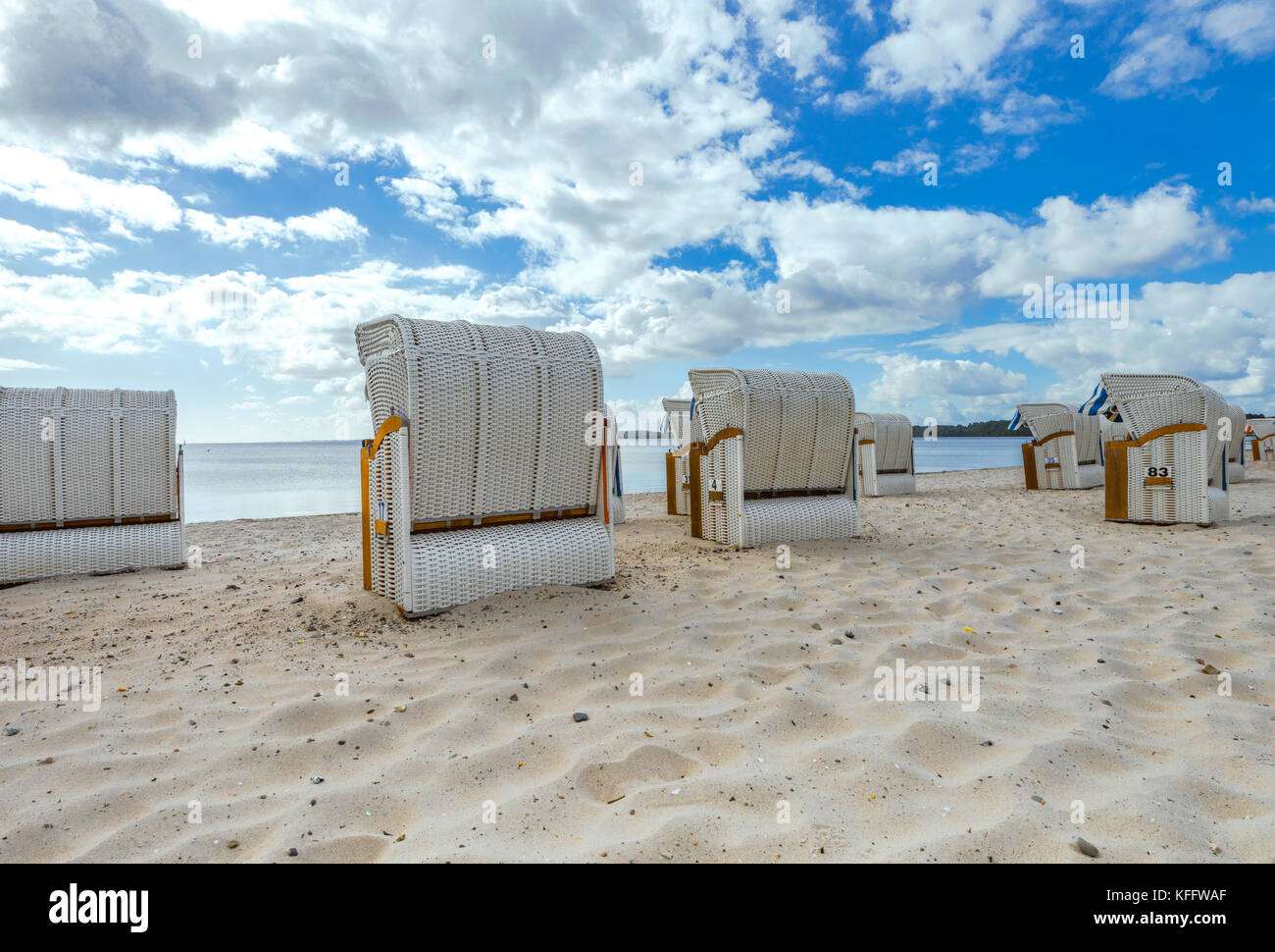 Scène de plage avec des chaises de plage et ciel bleu nuageux à Glücksburg, près de Flensburg, bord de mer de la mer Baltique en Allemagne du Nord Banque D'Images