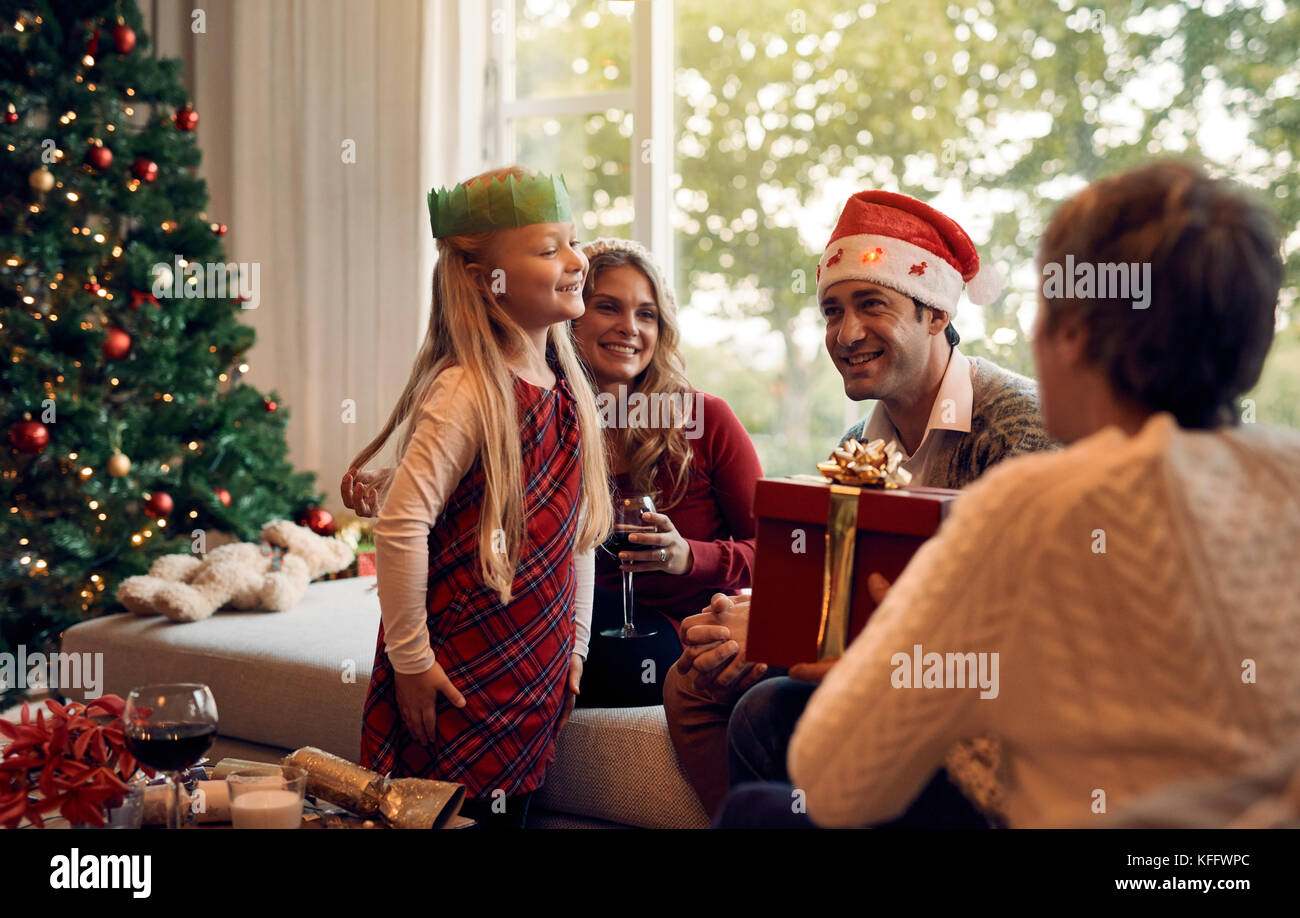 Femme mature en donnant un cadeau de Noël à sa petite-fille. Happy Family in living room la veille de Noël et échange de cadeaux. Banque D'Images