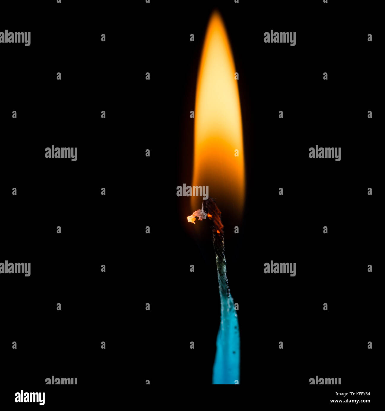 Un plan macro sur une flamme de combustion d'une mèche, tourné sur un fond noir. Banque D'Images