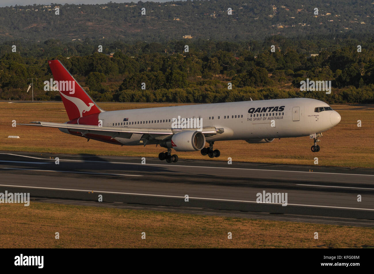 Air-sol, côté semi-shot sur un Boeing 767 de Qantas sur la piste d'atterrissage des aéronefs. n'est qu'en vol stationnaire au-dessus du sol. Banque D'Images