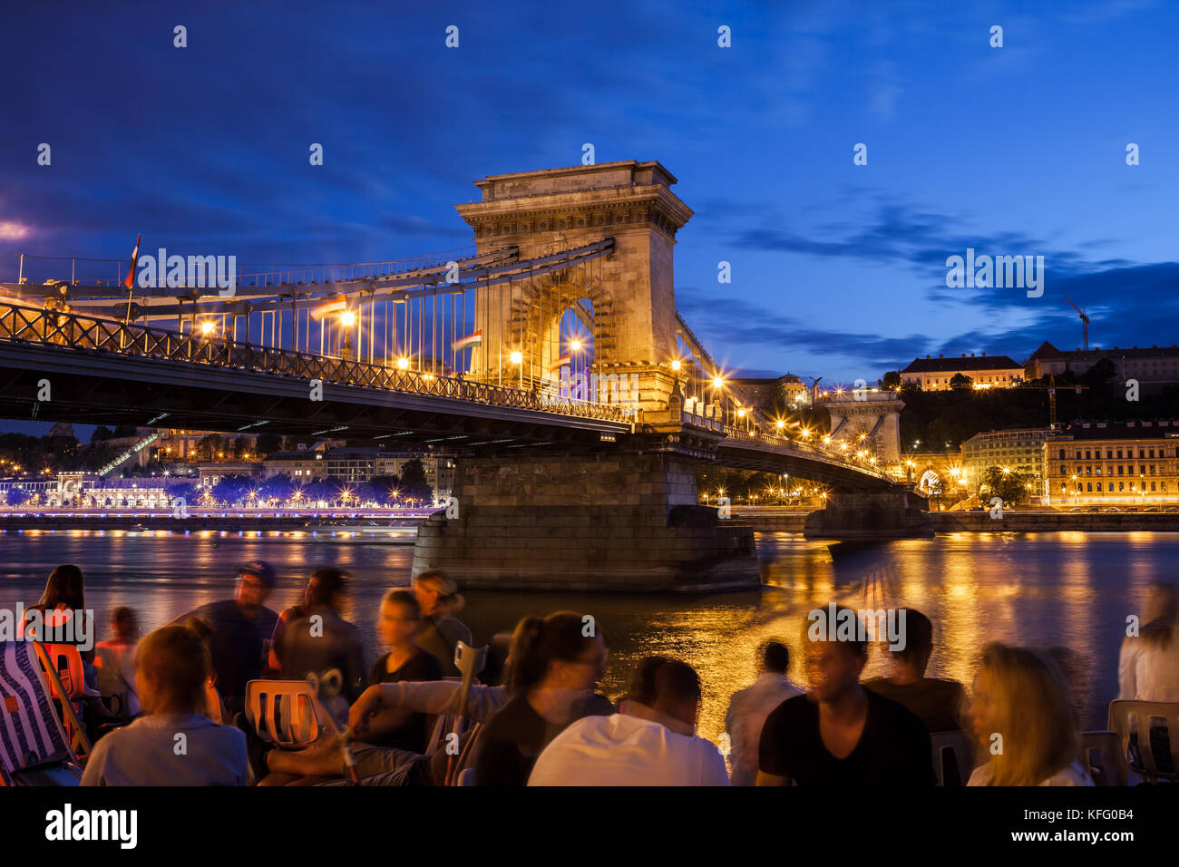 Budapest par nuit en Hongrie, city break, groupe de personnes et chill out à Danube près de pont à chaînes Széchenyi, à la fois locales et touristiques Banque D'Images