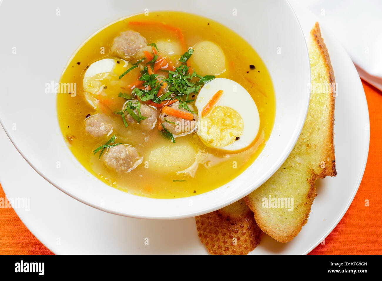 Soupe avec des œufs et des boulettes de viande dans un plat avec du pain blanc Banque D'Images