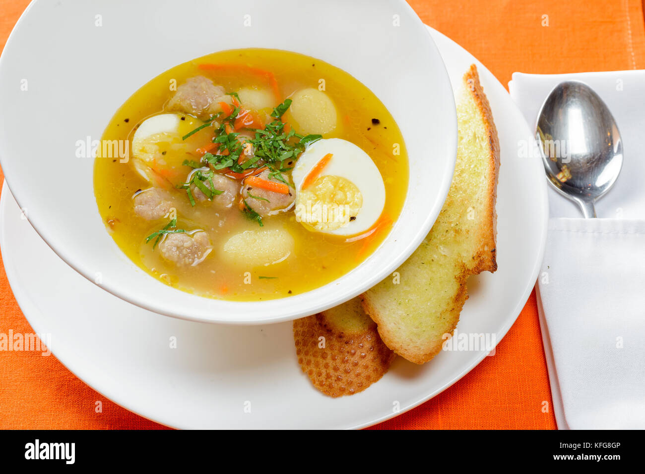 Soupe avec des œufs et des boulettes de viande dans un plat avec du pain blanc Banque D'Images