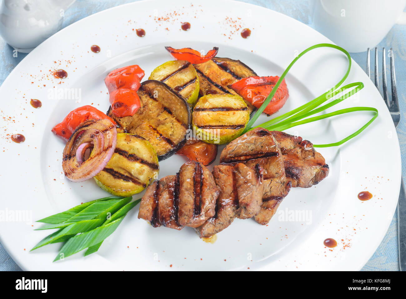 Une viande avec légumes grillés on white plate Banque D'Images