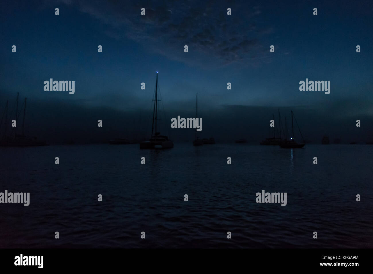 Feux de mouillage sur certains bateaux disponibles à l'ancre oscillante à fowey sur summers nuit. Banque D'Images