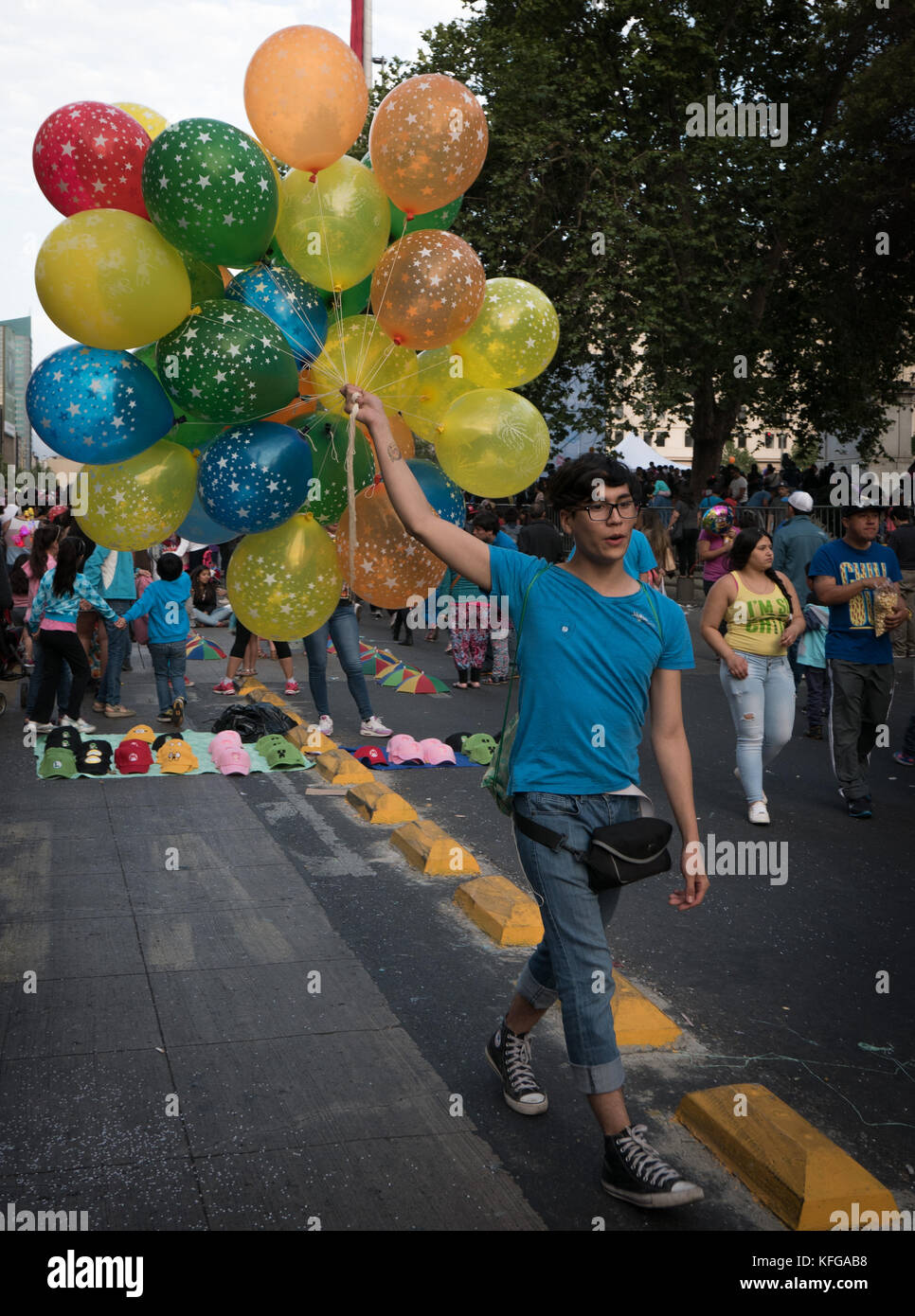 Kids walking down street holding up ballons multicolores à parade de Noël et festival à Buenos Aires en Argentine. Banque D'Images