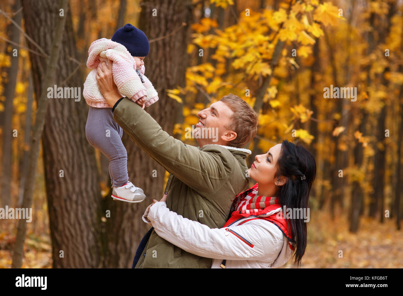 Les parents jouent avec petite fille in autumn park Banque D'Images