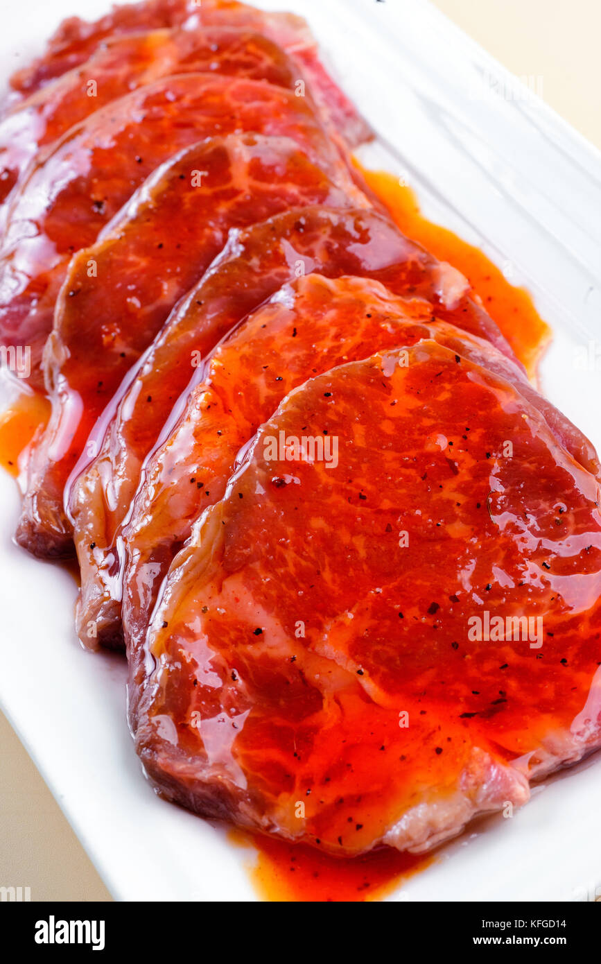 La viande fraîche en sauce rouge style asiatique sur un plat Banque D'Images