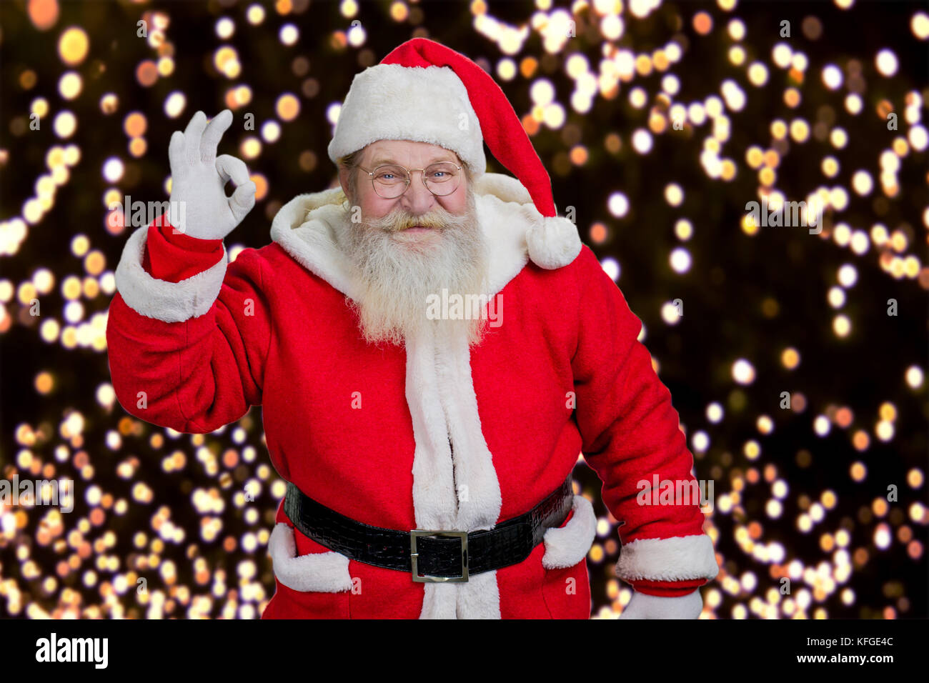 Santa montrant ok geste. père noël montrant part okay sign on ney année lumières fond. Banque D'Images