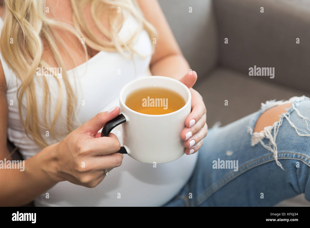 De longs cheveux blonds femme enceinte est titulaire d'une tasse de thé Banque D'Images