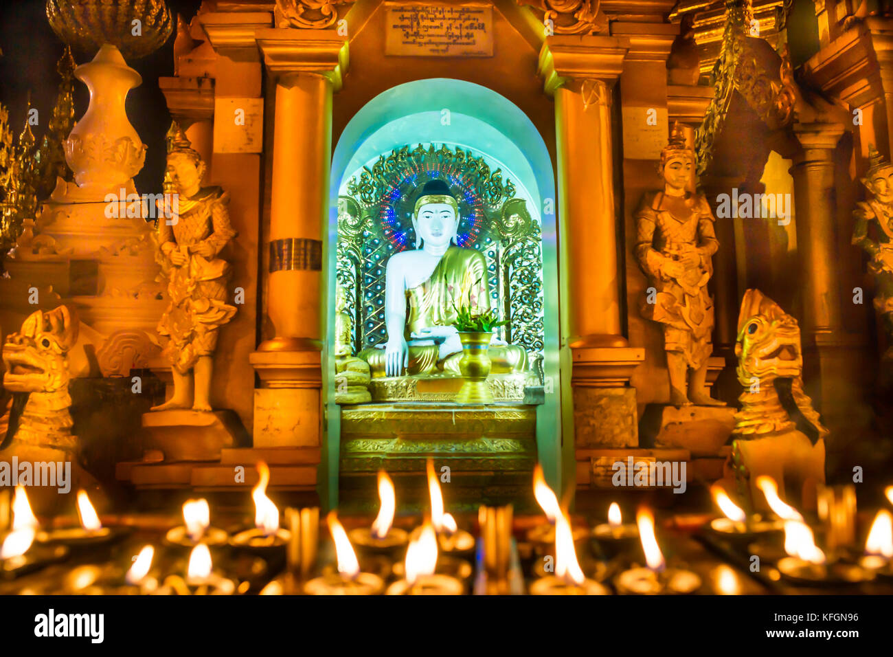 Le scintillement des bougies devant un buddah culte à la pagode Shwedagon à Yangon (Rangoon), le Myanmar (Birmanie) Banque D'Images