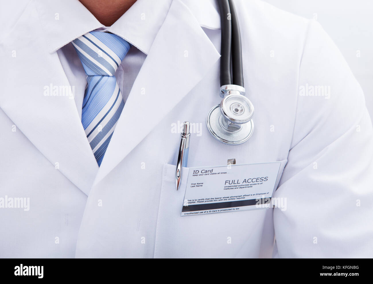 Close up de la poche d'un manteau de laboratoire avec une étiquette d'identité des médecins et un stylo et le disque de son stéthoscope autour du cou Banque D'Images