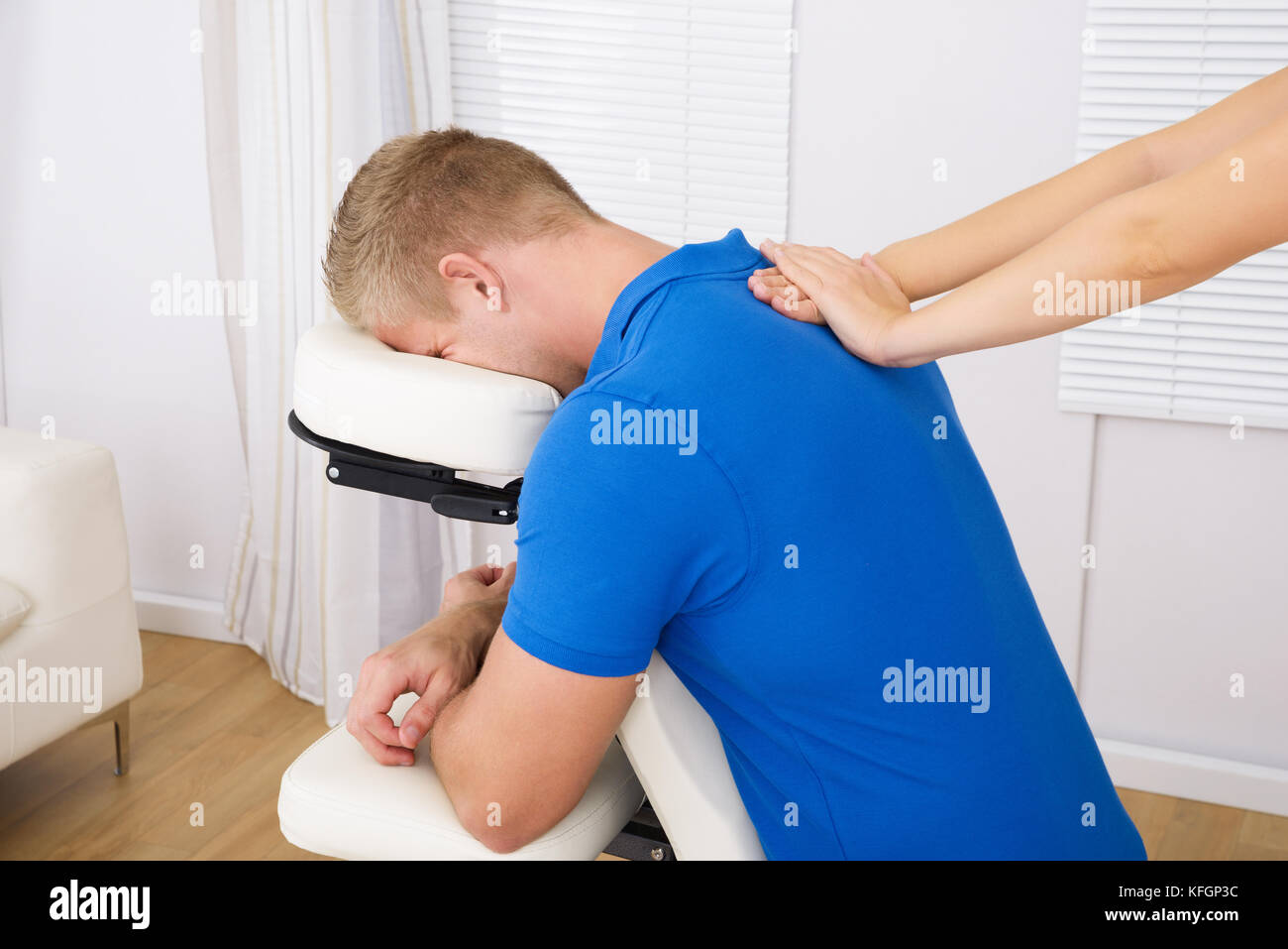Man receiving shoulder massage par female therapist Banque D'Images