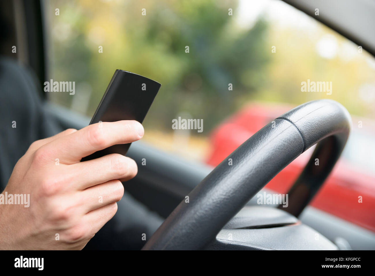 Gros plan d'Un homme en voiture tenant un téléphone portable Banque D'Images