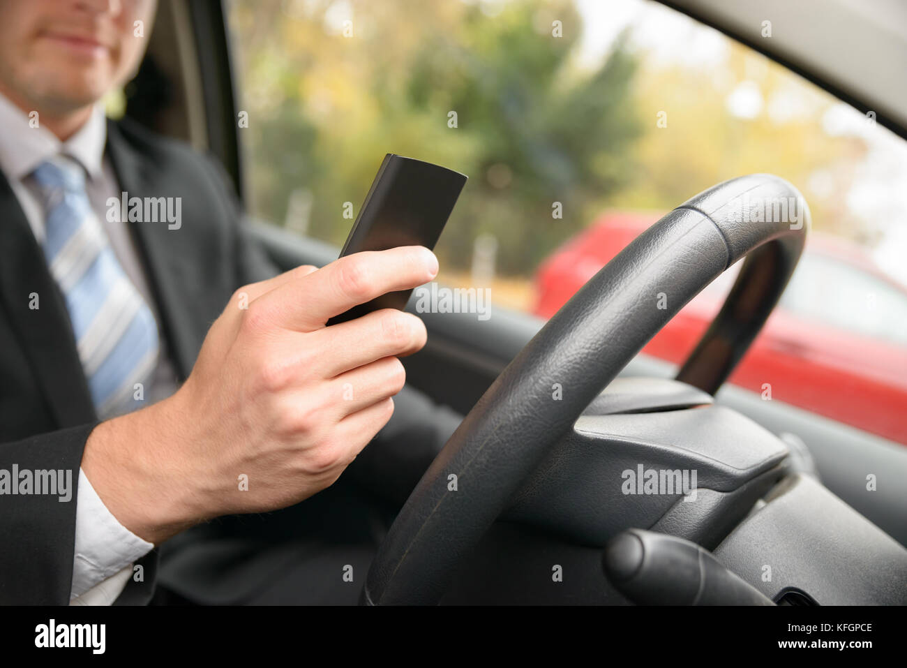 Gros plan d'Un homme en voiture tenant un téléphone portable Banque D'Images