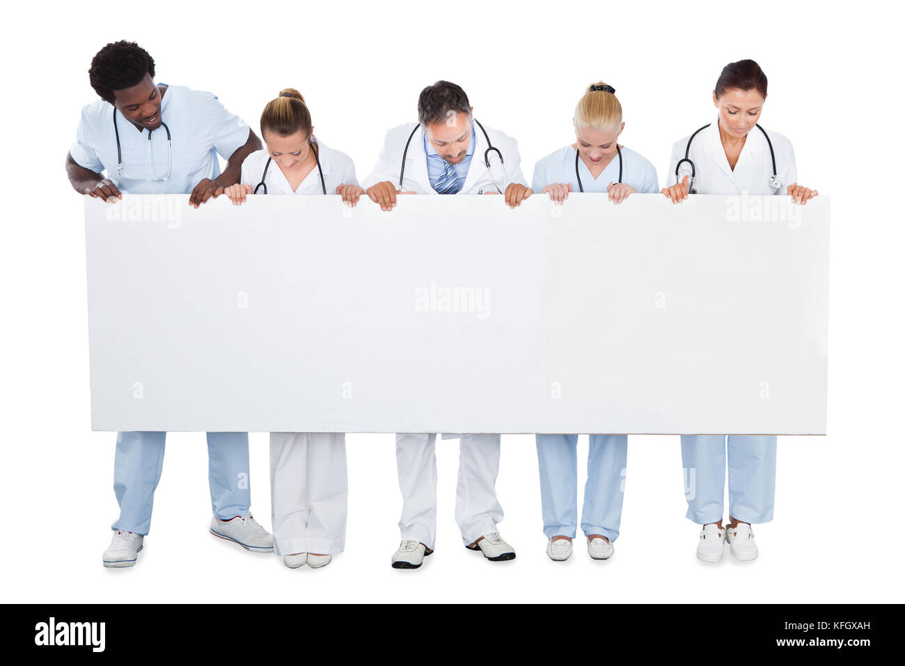 Toute l'équipe médicale multiethnique regardant un panneau d'affichage vierge sur fond blanc Banque D'Images