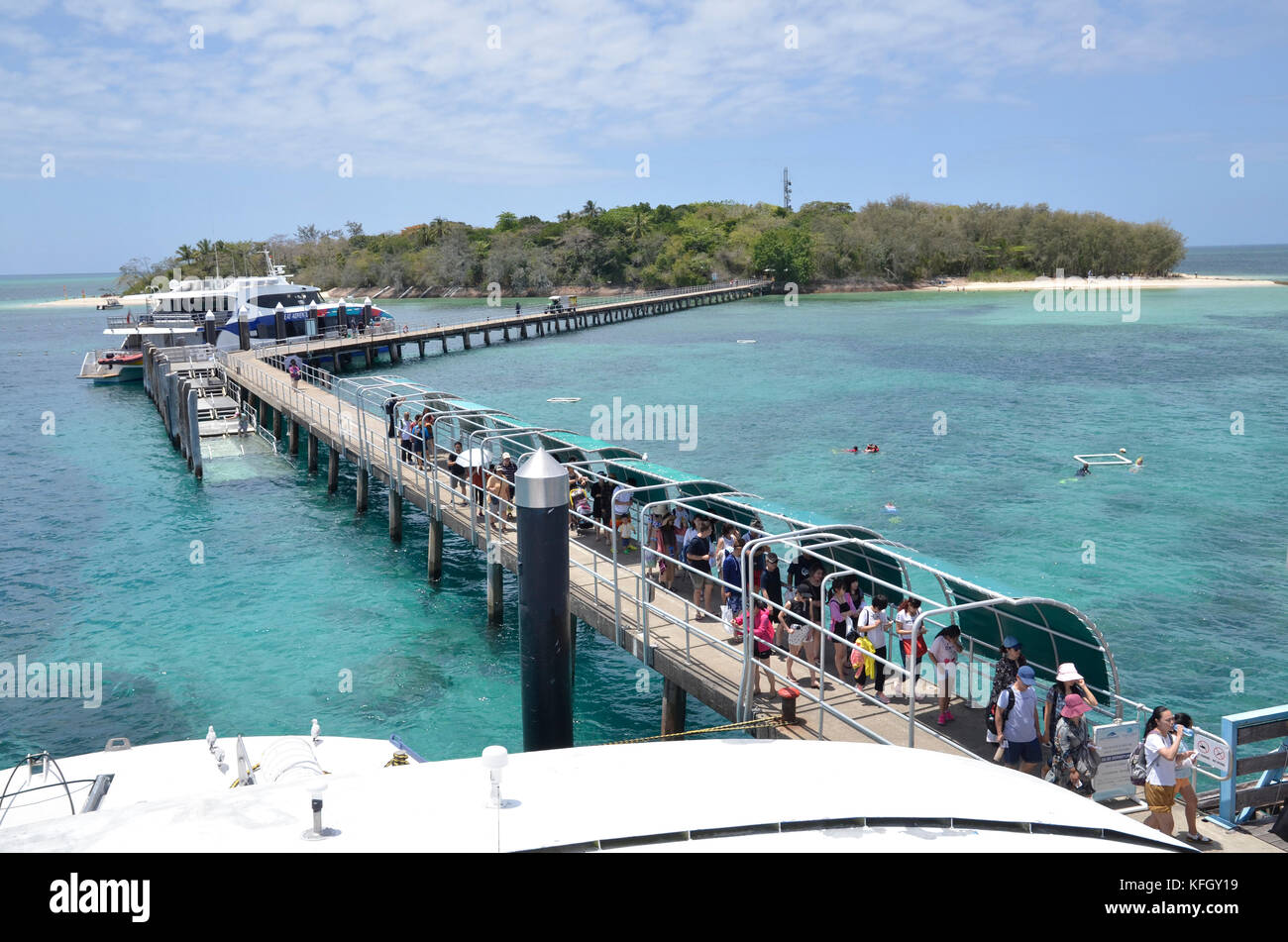 Un ferry de Cairns s'acquitte de touristes au quai à la station de Green Island sur la grande barrière de corail dans le Queensland du nord, Australie Banque D'Images