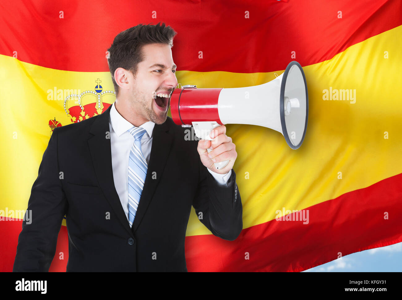 Businessman shouting par mégaphone devant Drapeau espagnol Banque D'Images