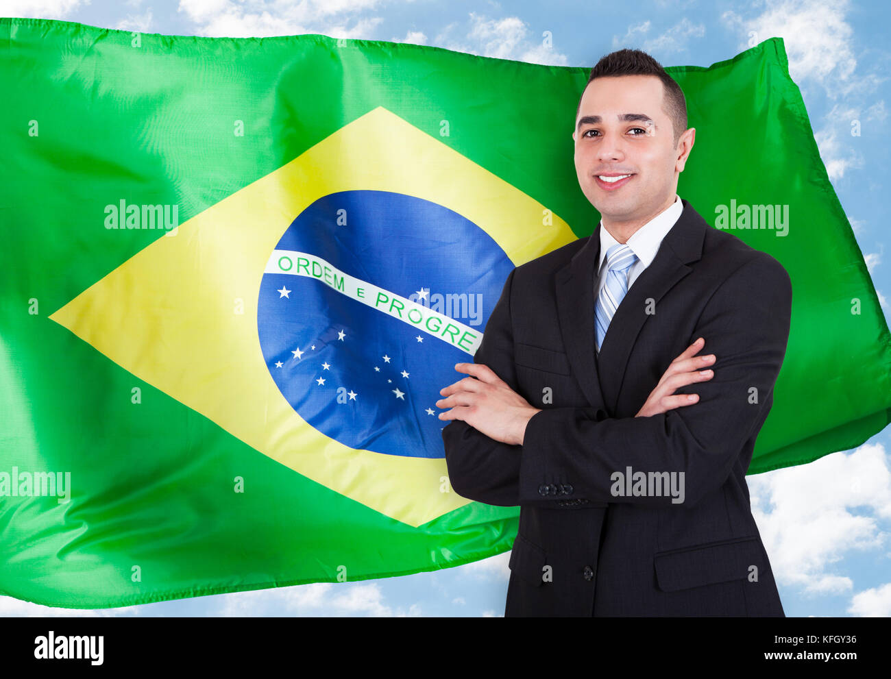 Portrait of young businessman standing in front of Brazilian flag Banque D'Images