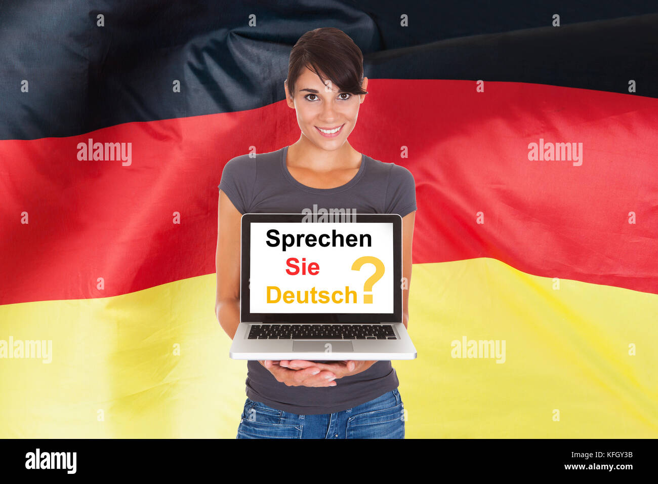 Young woman holding laptop poser parlez-vous allemand Banque D'Images