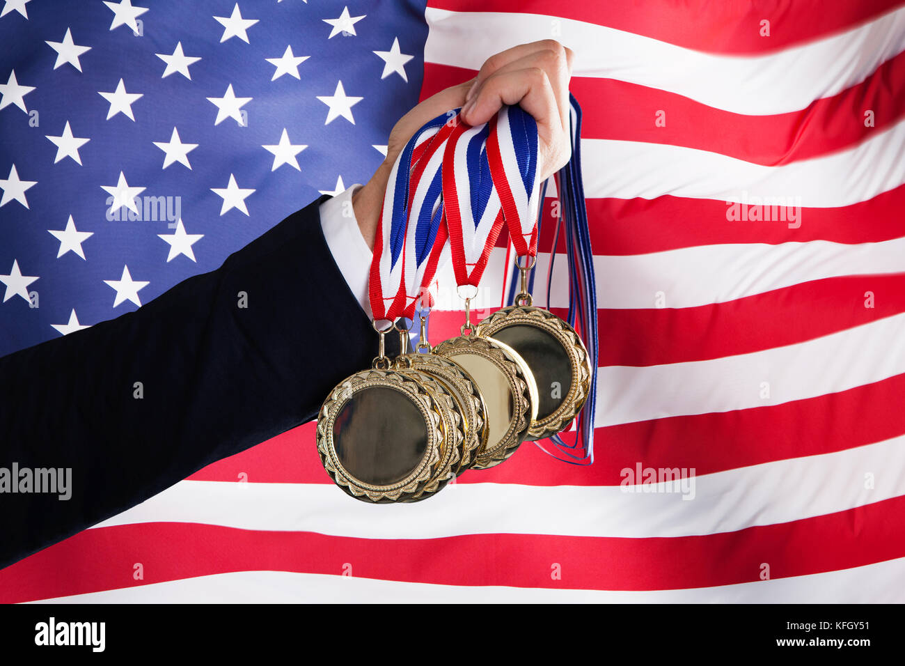 American businessman holding médailles en face du drapeau usa Banque D'Images