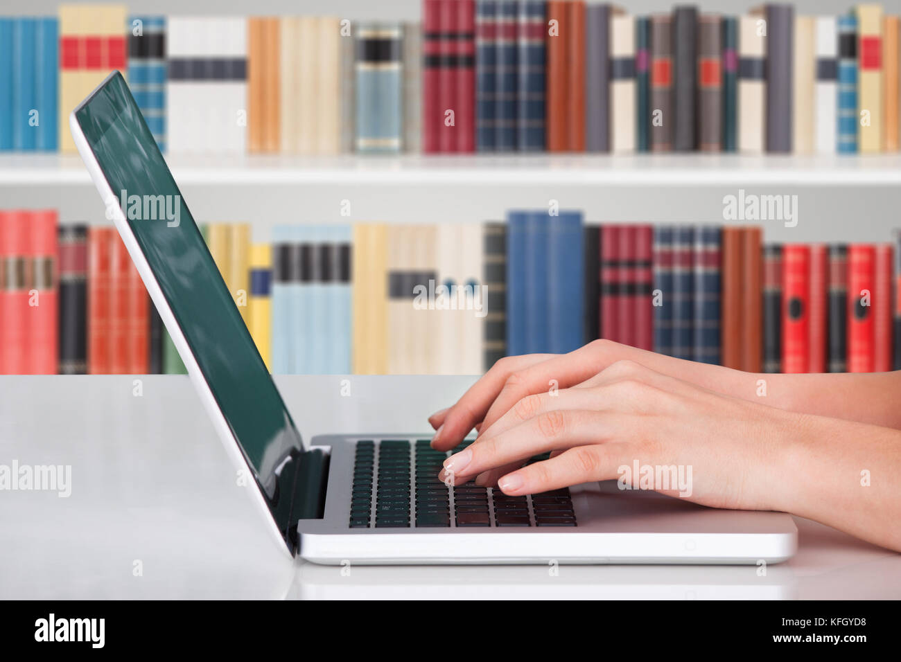 Gros plan d'Une personne saisissant des mains sur le bloc-notes dans la bibliothèque Banque D'Images