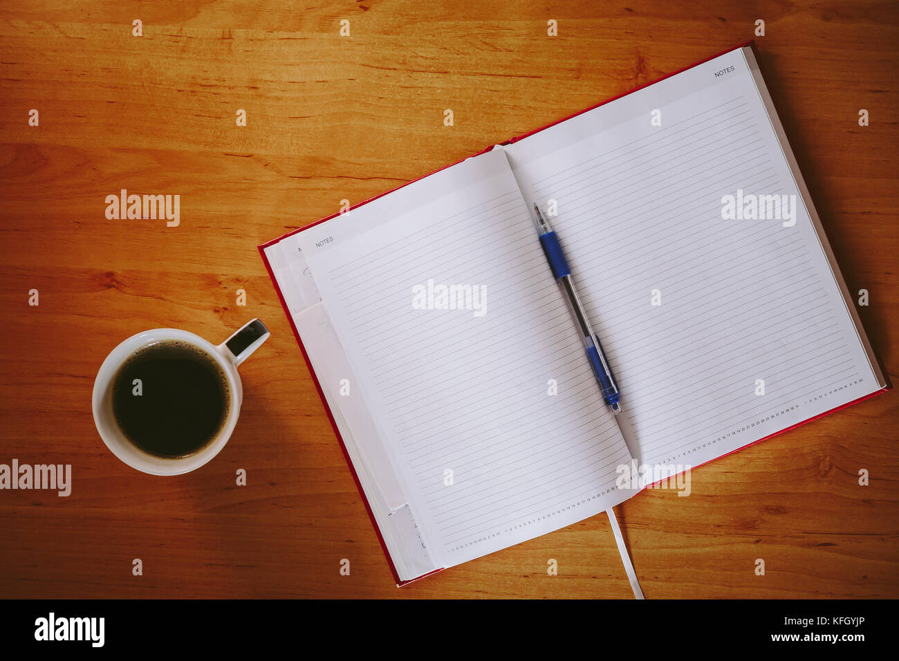 Cahier rouge et tasse de café sur un bureau bureau Banque D'Images