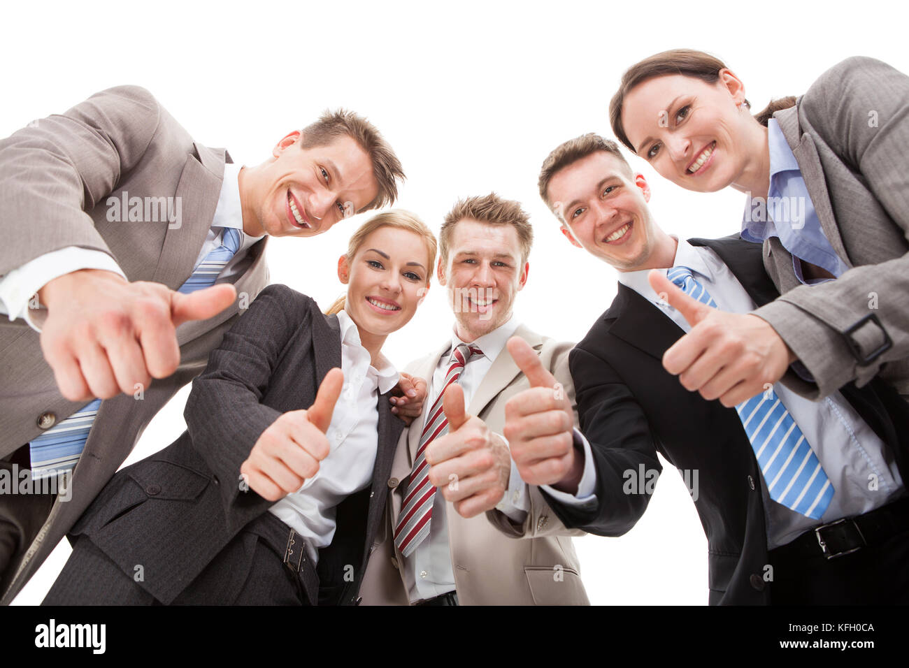 Low angle portrait of confident business team showing Thumbs up against white background Banque D'Images