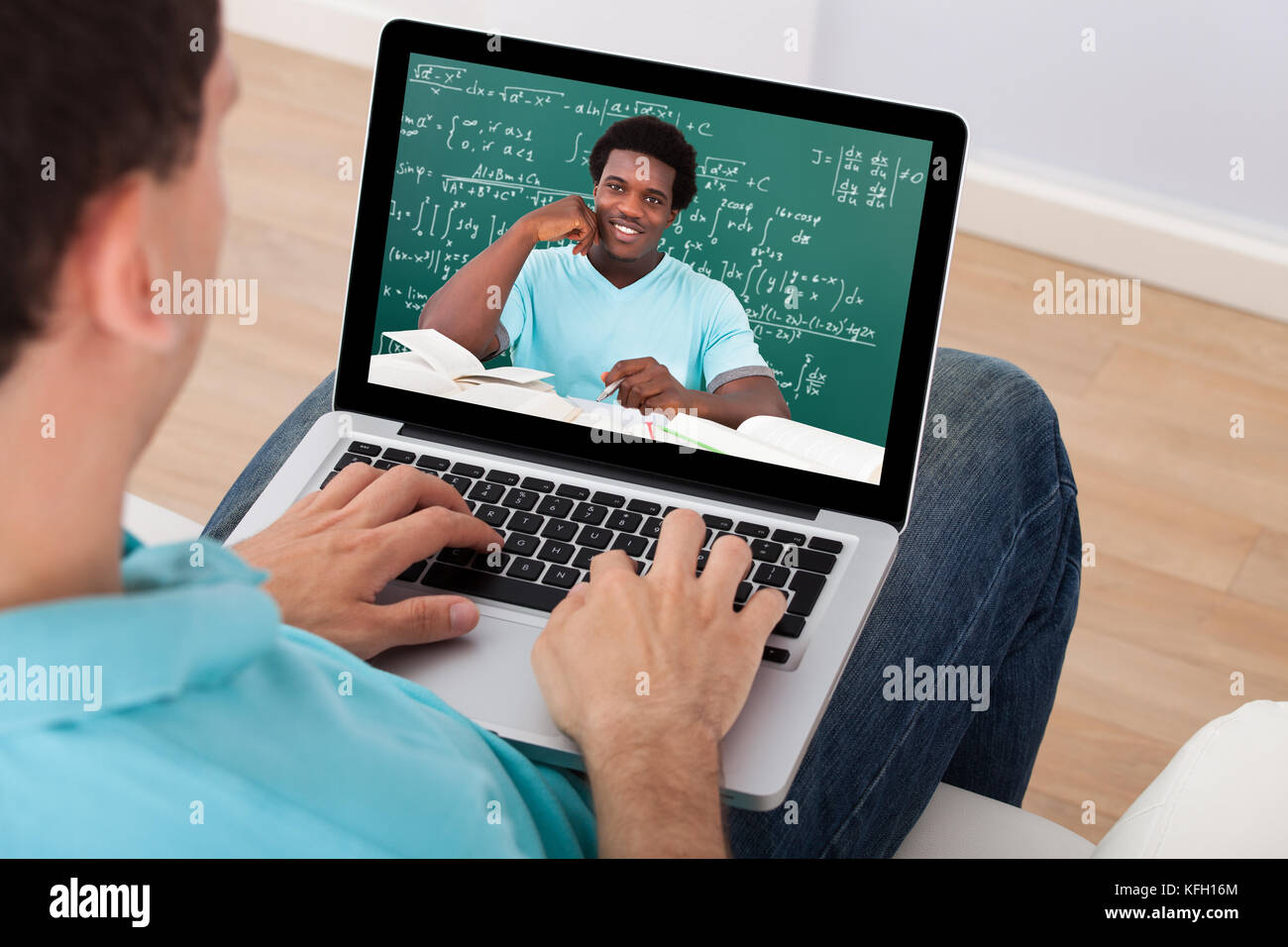 Mid adult man assistant à la conférence de mathématiques en ligne sur ordinateur portable à la maison Banque D'Images