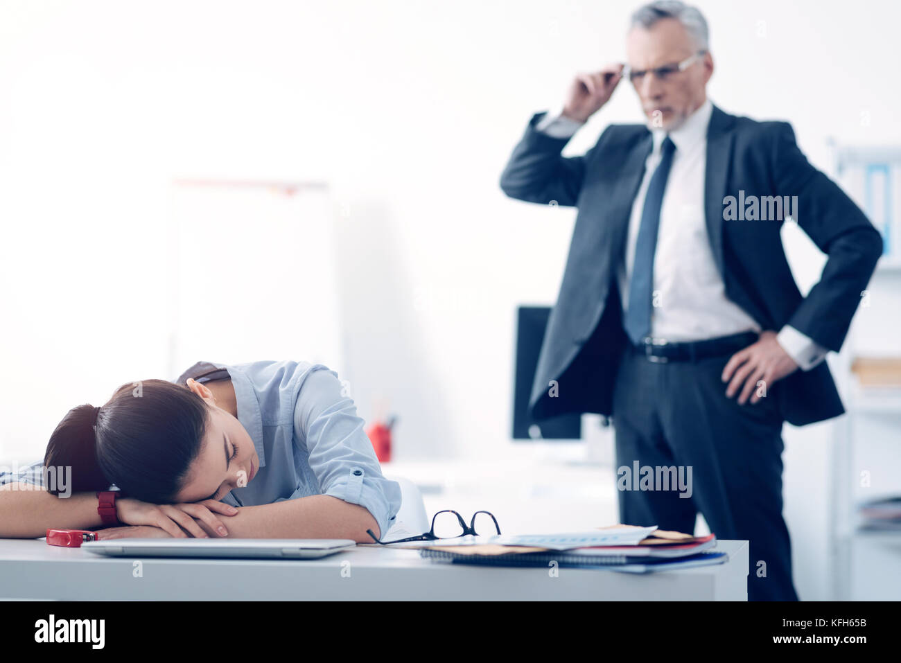 Abasourdi le chef looking à son employé de dormir au travail Banque D'Images