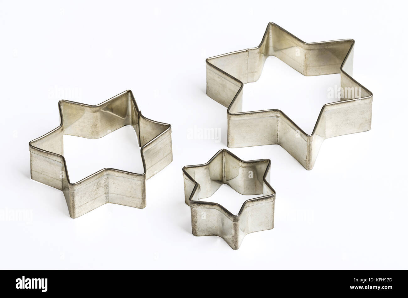 Trois star shaped christmas cookie cutters sur blanc. tin biscuit cutters, outil pour couper la pâte dans des formes particulières et de faire des caches. Banque D'Images