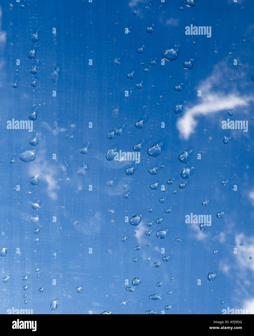Gouttes d'eau sur le verre sous le ciel. La texture, l'arrière-plan. Banque D'Images