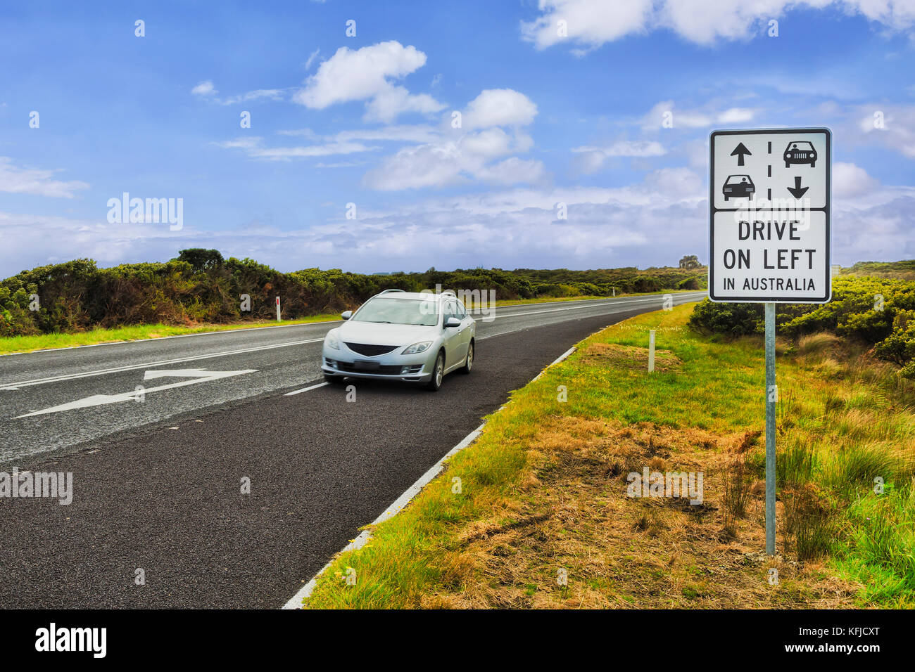 Conduire à gauche en Australie signe sur la route Great Ocean Road Victoria en regard de l'état rural régional speedway avec beaucoup de touristes d'outre-mer. Banque D'Images