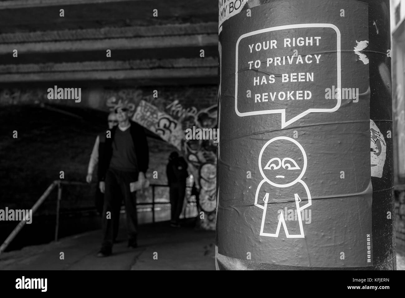 Street art poster accroché sur un tunnel près de la colonne de l'artiste subdude avec homme stylisé et cartoon avec slogan "Votre droit à la vie privée a été révoquée". Banque D'Images