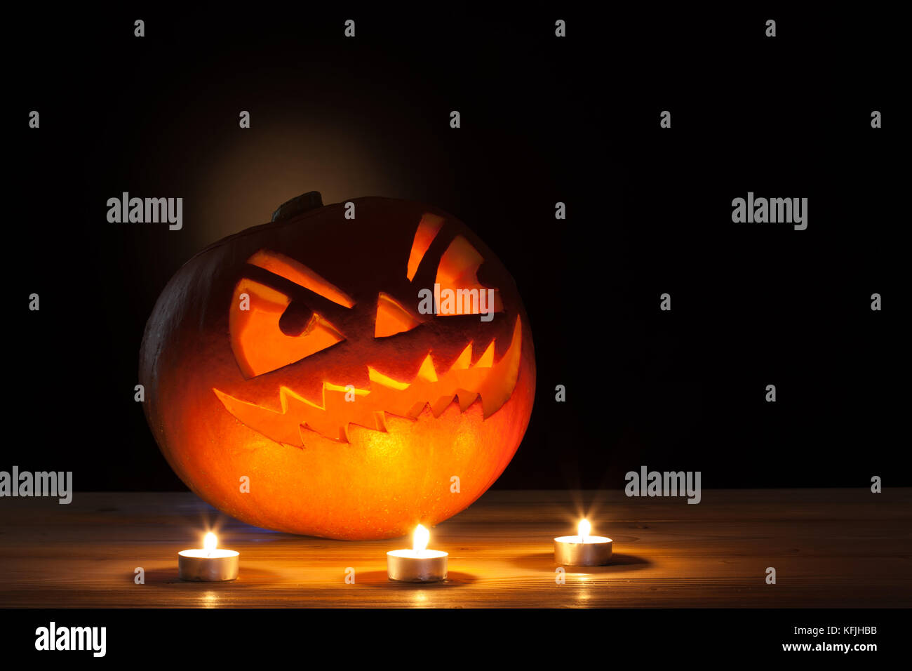 Halloween citrouille avec trois bougies sur table en bois. Banque D'Images