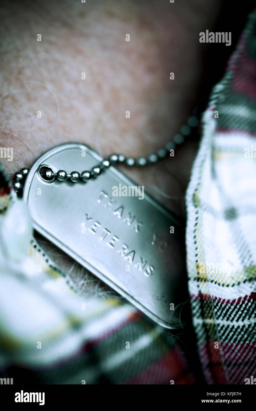 Closeup of a dog tag avec le texte gravé dans des anciens combattants vous remercie il accroché au cou d'un vieux caucasian man Banque D'Images
