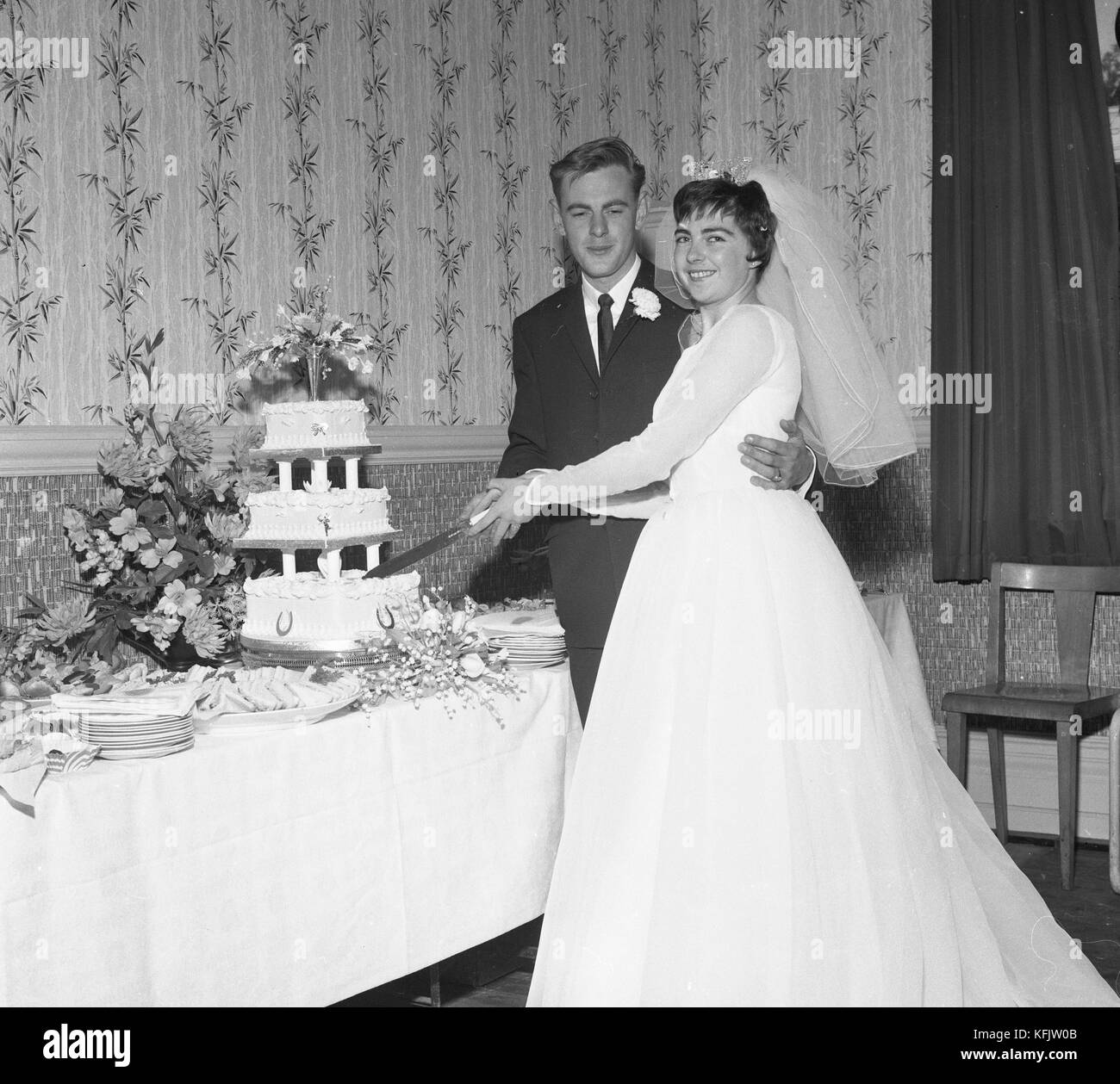 Couper le gâteau. le mariage de M. et Mme Morgan à l'église paroissiale de St Jean l'Evangéliste à parkstone, Poole, dorset. c1965. photo par Tony henshaw Banque D'Images