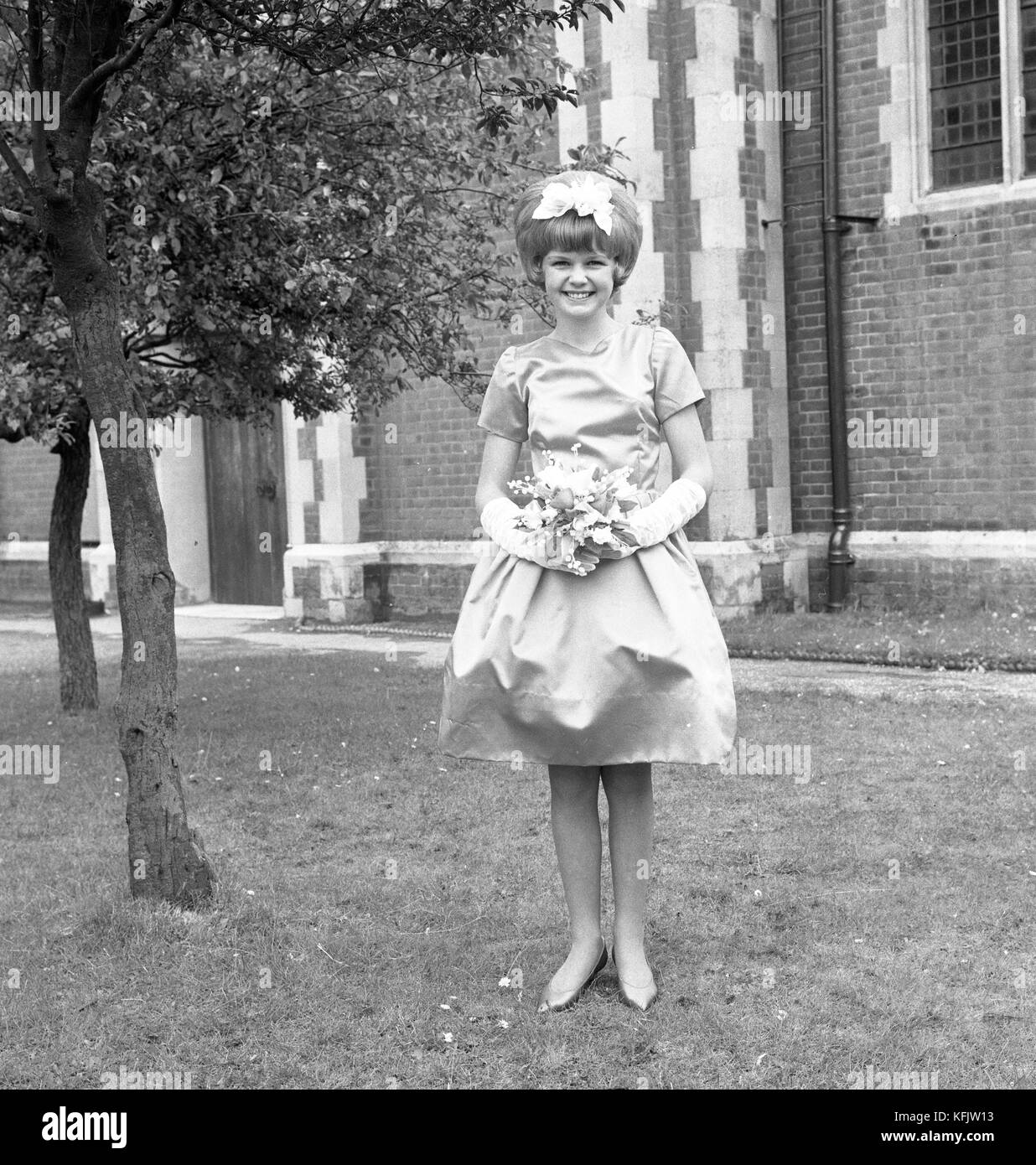 Une demoiselle d'honneur au mariage de Mr & Mme Morgan à l'église paroissiale de St Jean l'Evangéliste à parkstone, Poole, dorset. c1965. photo par Tony henshaw Banque D'Images