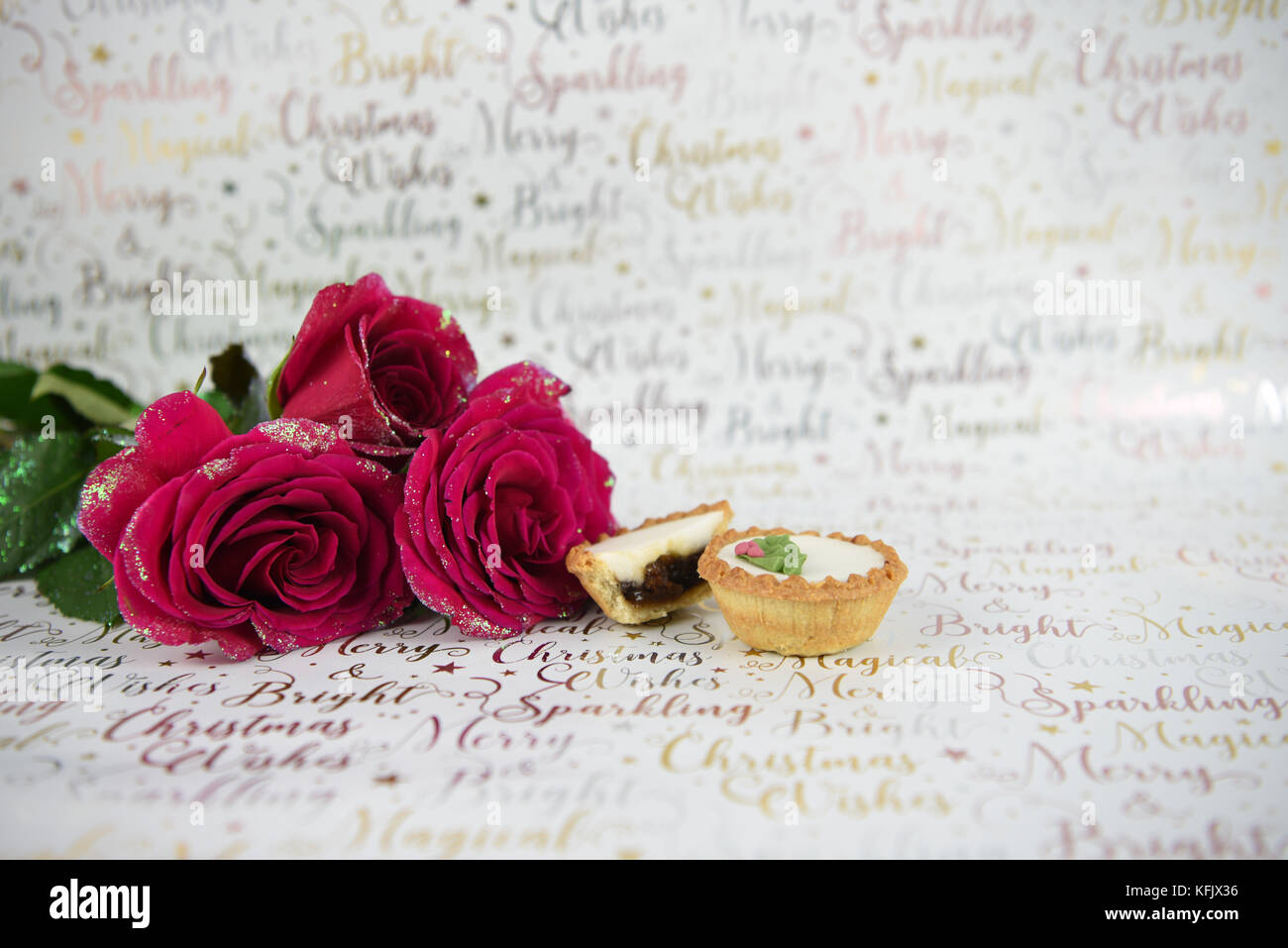 Noël Nourriture photographie image avec xmas glitter roses rouges et petits pâtés glacé brillant blanc sur fond de papier d'emballage avec l'écriture de fête Banque D'Images