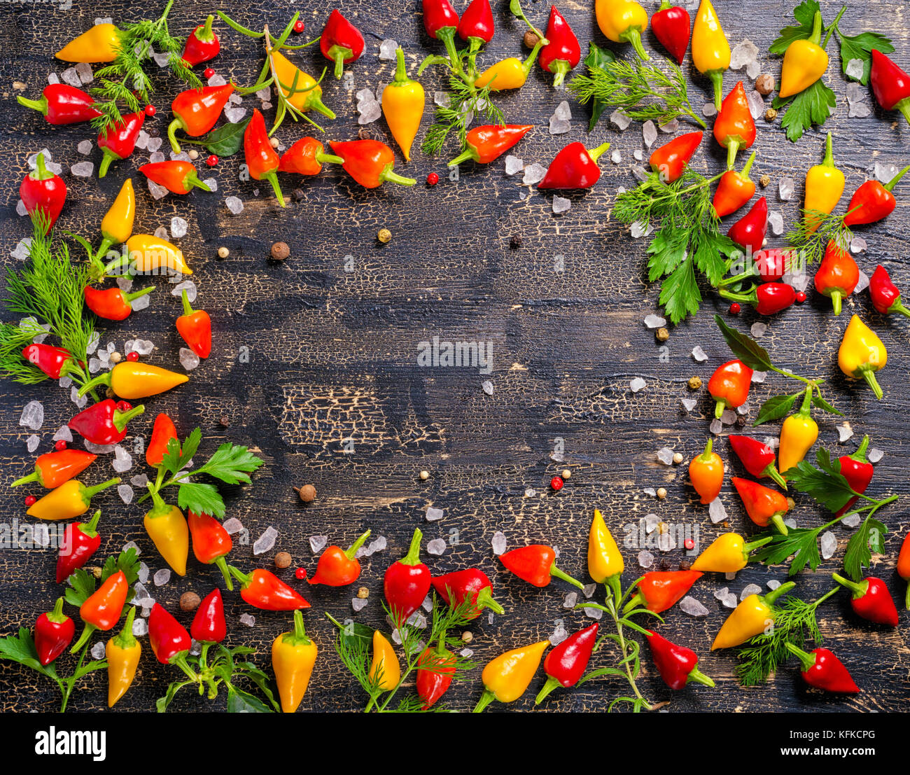 Vue de dessus d'épices à la frontière de dry et Hot Chili Peppers, sel de mer, verdure différentes fissures sur fond noir Banque D'Images