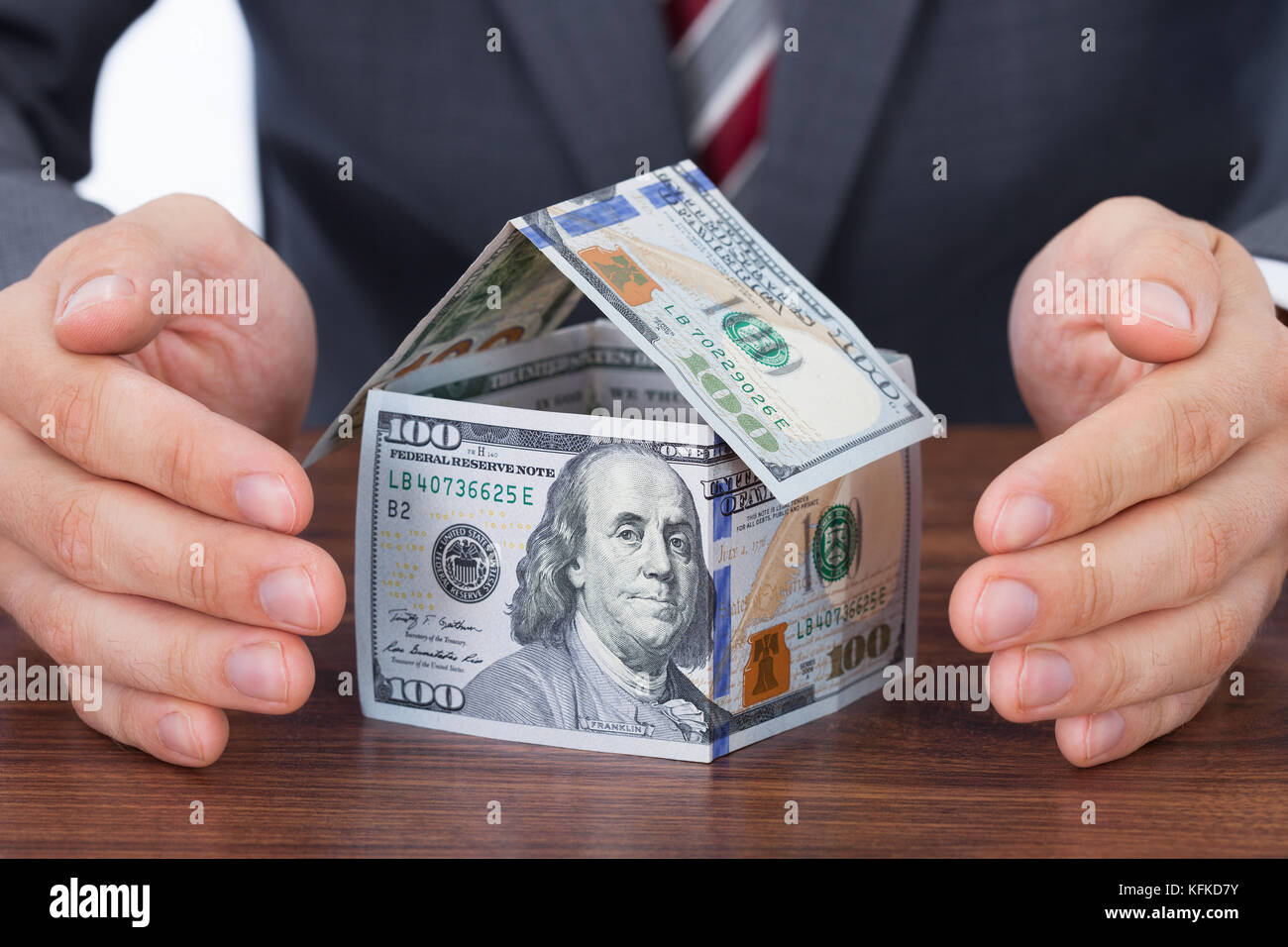 Portrait d'affaires à l'abri maison faite avec des billets de banque sur la table Banque D'Images