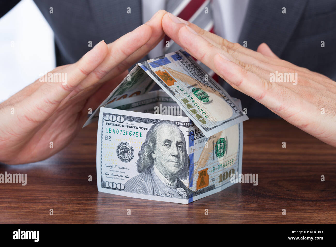 Portrait d'affaires à l'abri maison faite avec des billets de banque sur la table Banque D'Images