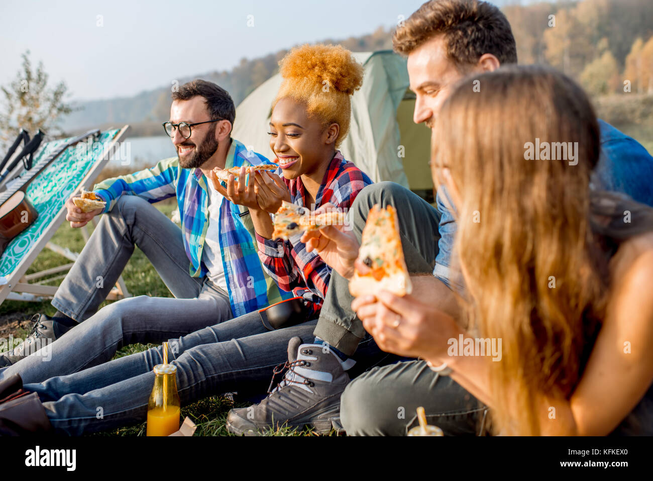 Les amis de manger une pizza au camping Banque D'Images