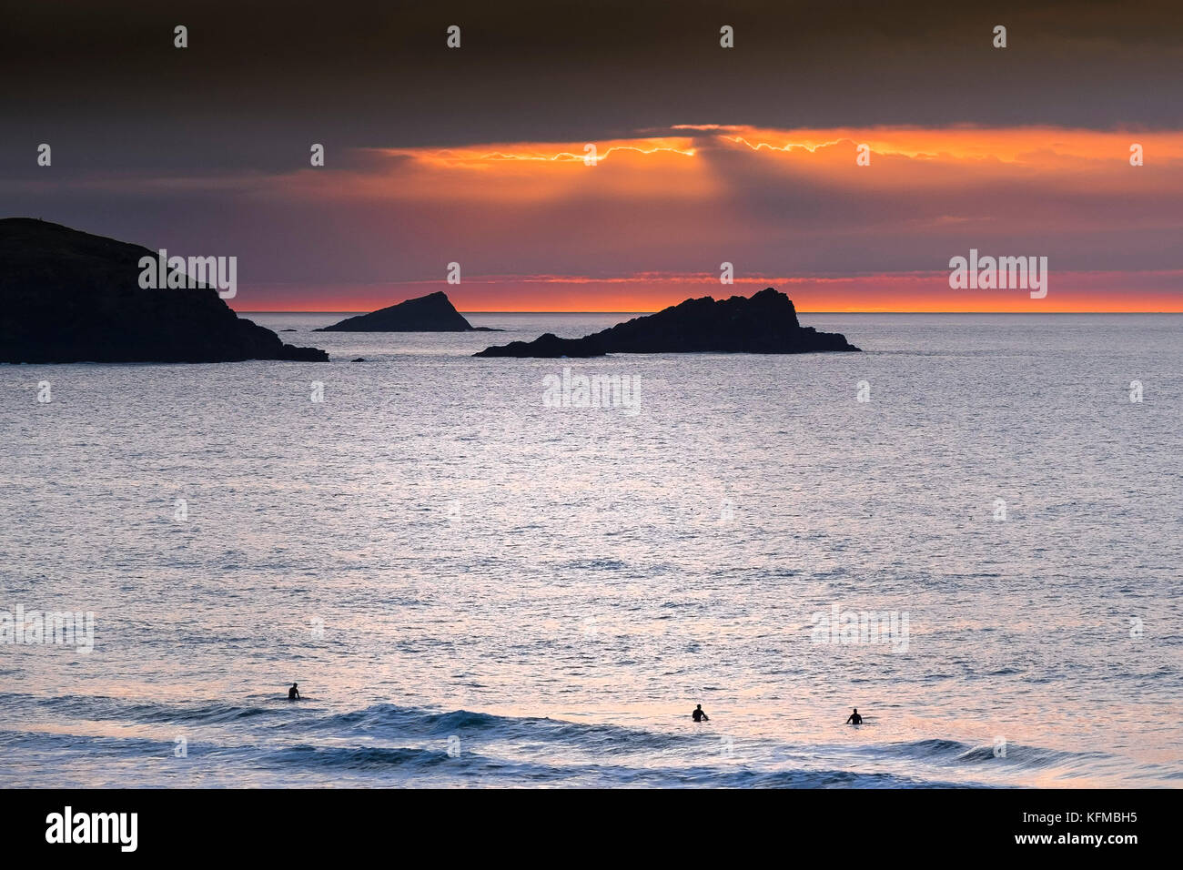 Coucher de soleil spectaculaire - la poule et le poussin de petites îles au large de pointe sont seeen Pentire en silhouette alors que le soleil se couche sur Cornwall dans Fistral. Banque D'Images