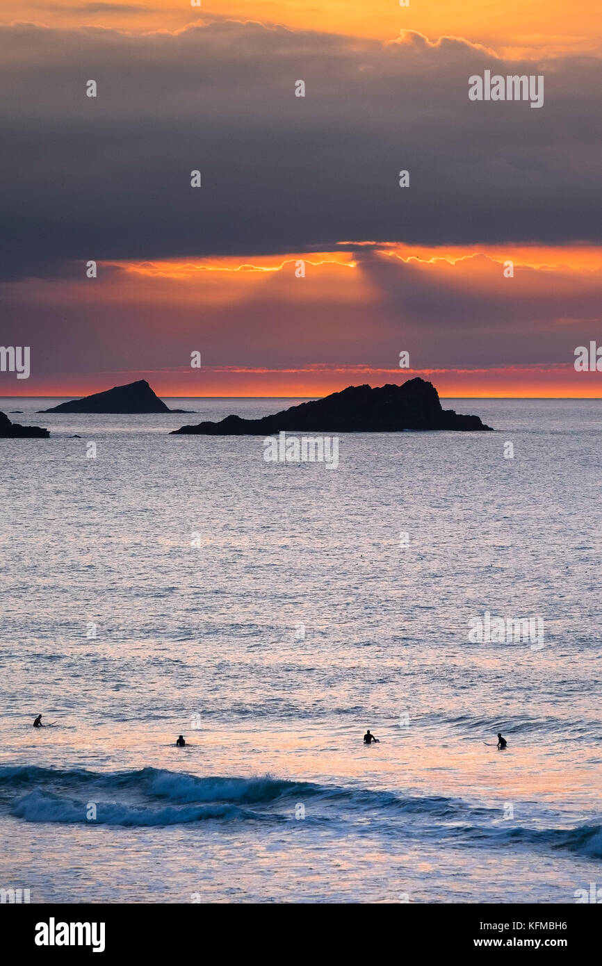 Coucher de soleil spectaculaire - la poule et le poussin de petites îles au large de pointe sont seeen Pentire en silhouette alors que le soleil se couche sur Cornwall dans Fistral. Banque D'Images