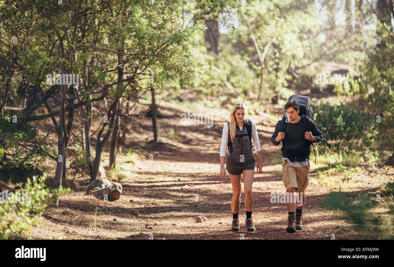 L'homme et la femme les randonneurs randonnée sur sentier forestier. Explorer la nature couple randonneur marchant à travers les bois. Banque D'Images