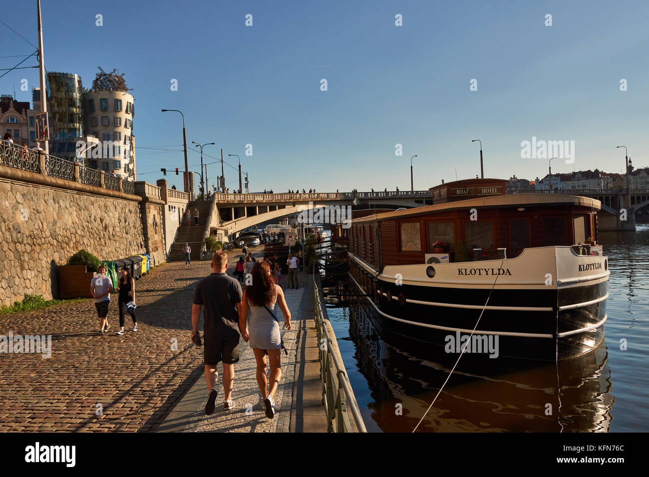 Les gens se promener le long de la rivière Vltava à Prague, Tchéquie juste sous la maison qui danse conçu par Frank Gehry Banque D'Images