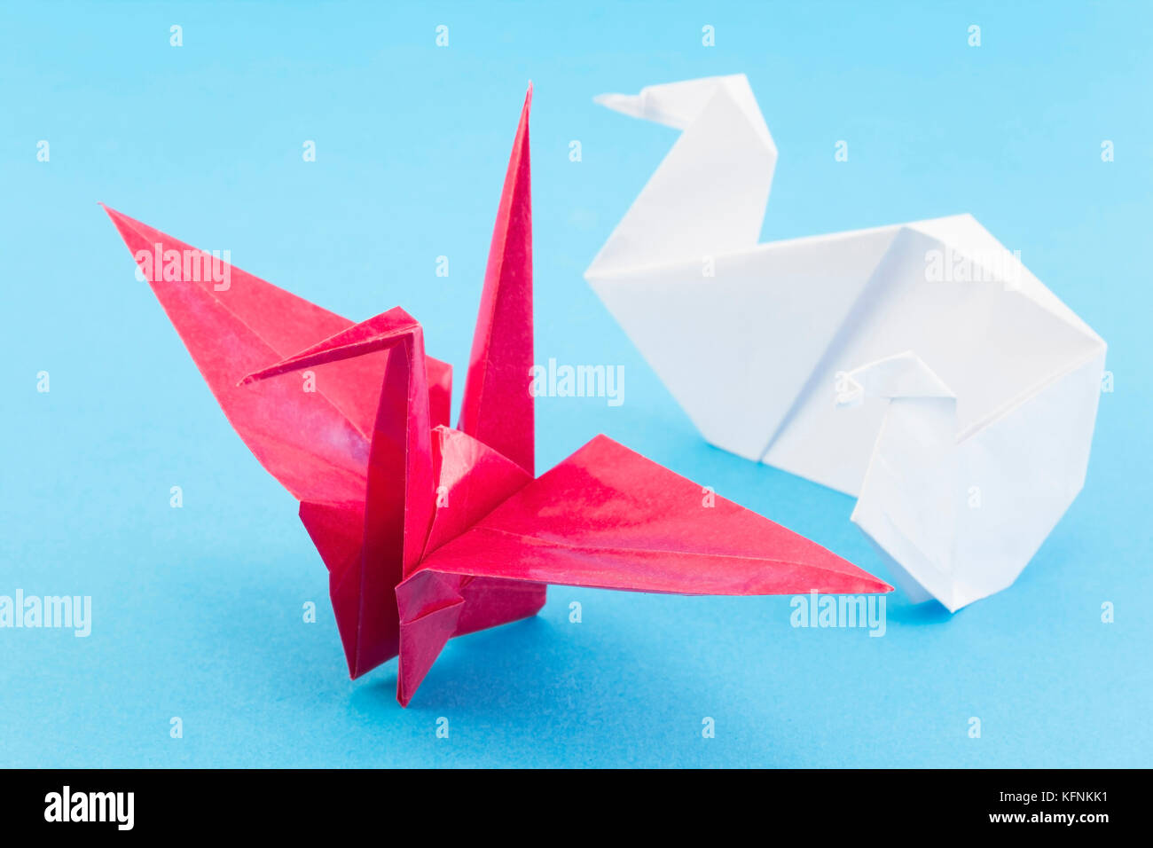 Oiseaux origami sur fond bleu. Banque D'Images